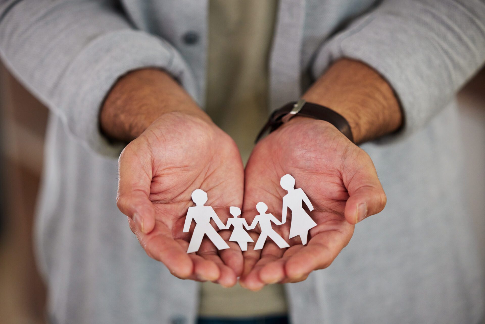 The future is in your hands. a businessman holding a cutout of people. Insurance Coverage